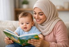 صورة لأم محجبة تقرأ كتاب لطفل عمره 6 شهور