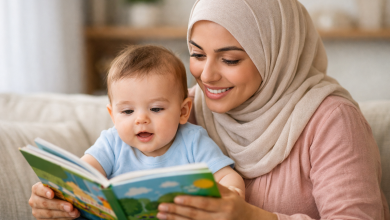 صورة لأم محجبة تقرأ كتاب لطفل عمره 6 شهور